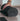 man with hand on rolled Rituil™ recycled cotton yoga rug in ash or black color #color_ash