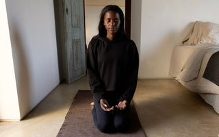 woman meditating on RItuil yoga rug and meditation seat