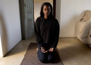 woman meditating on RItuil yoga rug and meditation seat