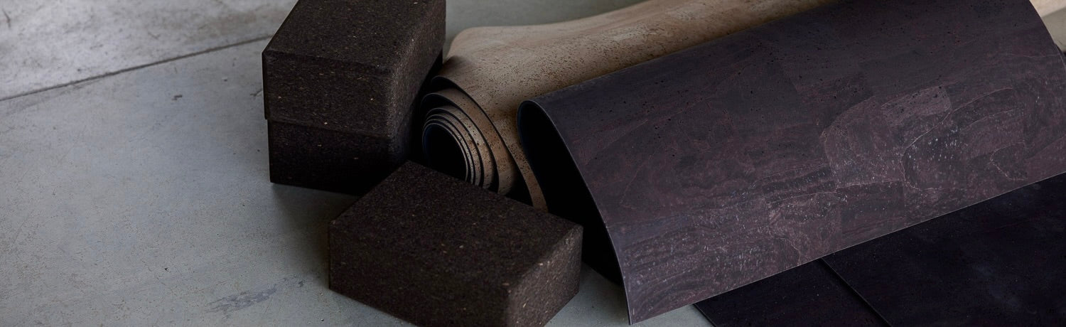 cork yoga mats and cork block rolled up against stone 