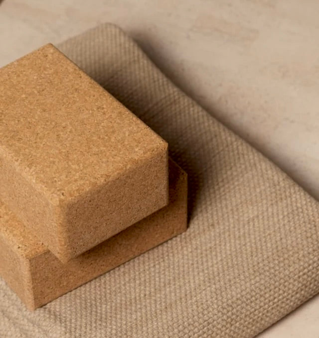 two natural cork yoga blocks on top on natural cotton yoga rug #color_bone #color_sand