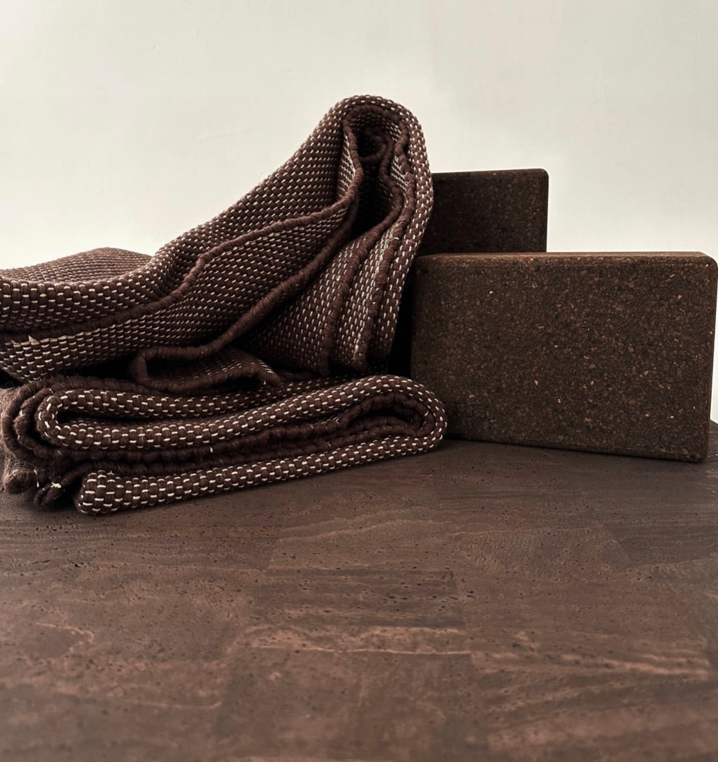 restorative yoga rug that is heavyweight and oversized and sustainable made with recycled cotton paired with brown cork yoga blocks 