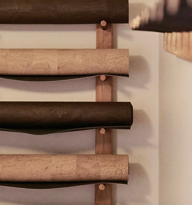 Rituil sustainable natural brown and tan cork leather yoga mats featuring a non-slip, non-toxic, non-pvc surface rolled up on wall rack