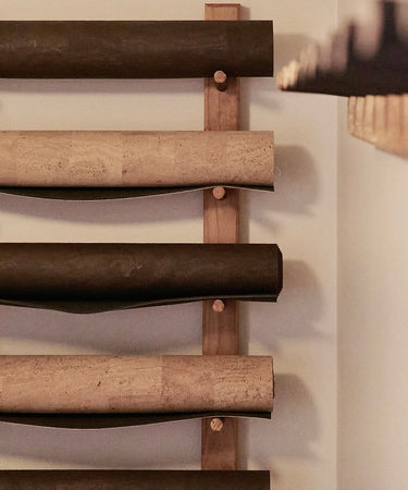 RITUIL CORK YOGA MATS ROLLED UP ON STUDIO WALL RACK