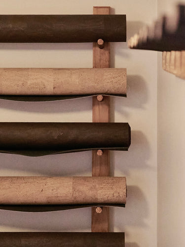 RITUIL CORK YOGA MATS ROLLED UP ON STUDIO WALL RACK