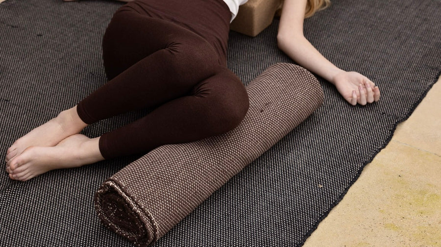 woman laying on cotton restorative rug using rug as bolster