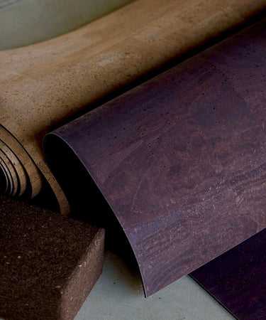 Rolled up cork yoga mat and cork blocks on concrete floor