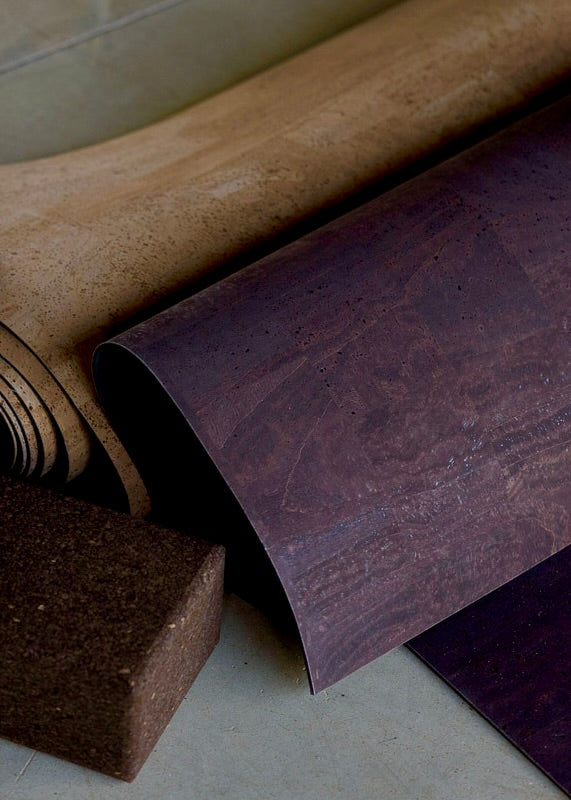 Rolled up cork yoga mat and cork blocks on concrete floor
