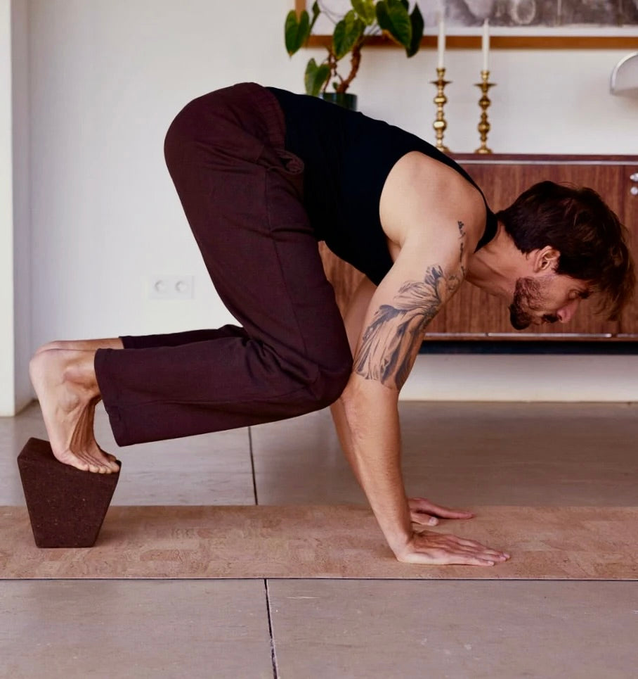 man with hands on non slip cork yoga mat  in crow