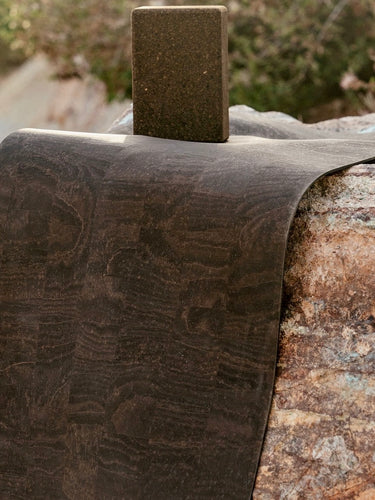 Luxury brown leather yoga mat on rocks