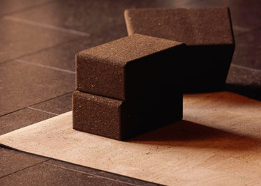 Rituil sustainable natural brown cork yoga blocks on top of cork leather yoga mats featuring a non-slip, non-toxic, pvc free surface