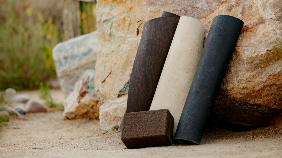 rolled up rituil cork yoga mats and block on rocks