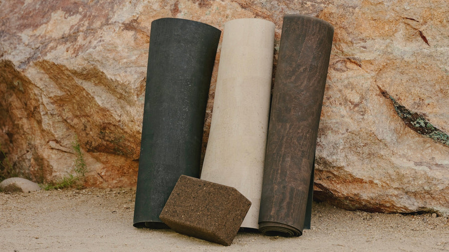 rituil cork leather yoga mats rolled up against a rock