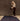 Woman standing on a black yoga rug setting up for meditation. #color_ash