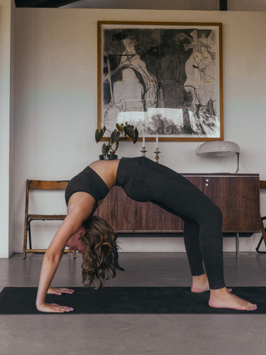 Cork yoga mat non-slip grip black Rituil with woman in a backbend pose