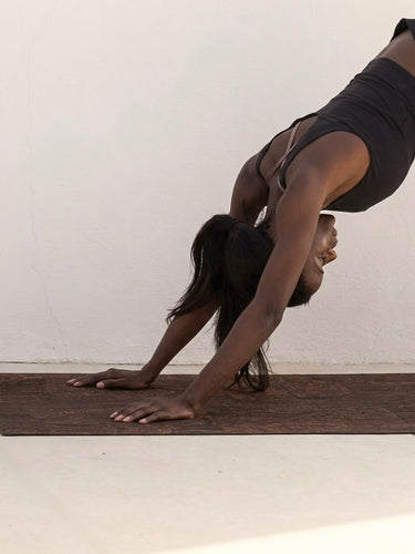 Cork yoga mat non-slip grip brown Rituil with woman in downward dog pose