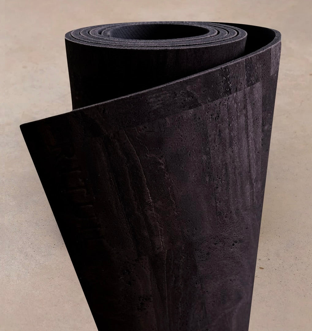 Extra long 6mm thick Rituil cork leather studio mat rolled in a rich black colorway, showcasing sustainable Portuguese craftsmanship.
