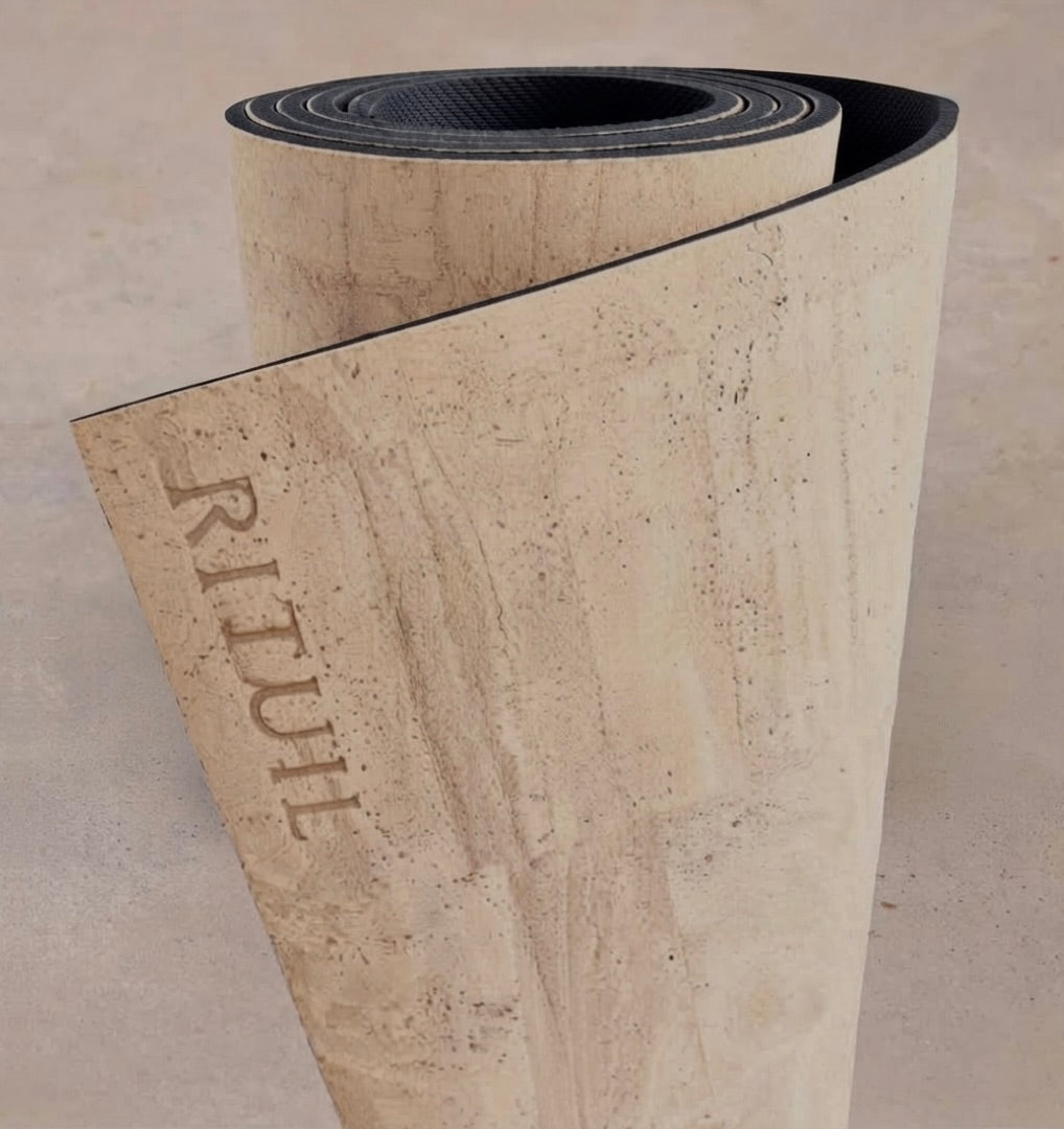 Extra long 6mm thick Rituil cork leather studio mat rolled in a light cream colorway, designed for studio pilates and movement spaces.