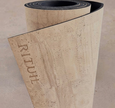 Extra long 6mm thick Rituil cork leather studio mat rolled in a light cream colorway, designed for studio pilates and movement spaces.