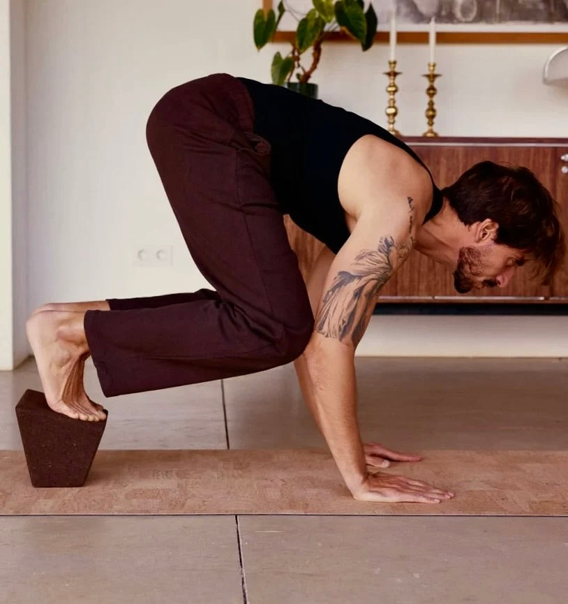 Rituil sustainable natural tan cork leather yoga mat featuring a non-slip, non-toxic, pvc free, man in crow pose 