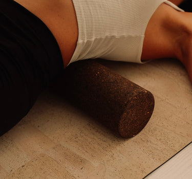 Woman practicing on Rituil sustainable Portuguese cork massge roller for deep tissue muscle recovery shown on top of cork yoga mat