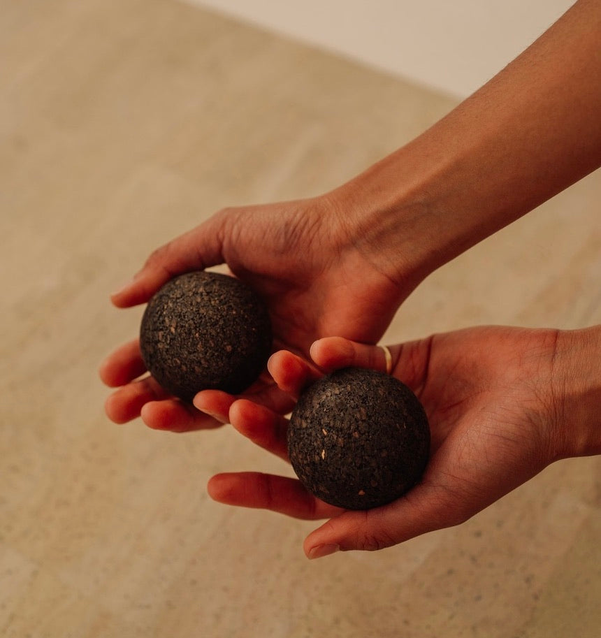 Rituil sustainable Portuguese cork massge balls for yoga, Pilates core workouts, and deep tissue muscle recovery shown with woman holding set in hand on top of cork yoga mat