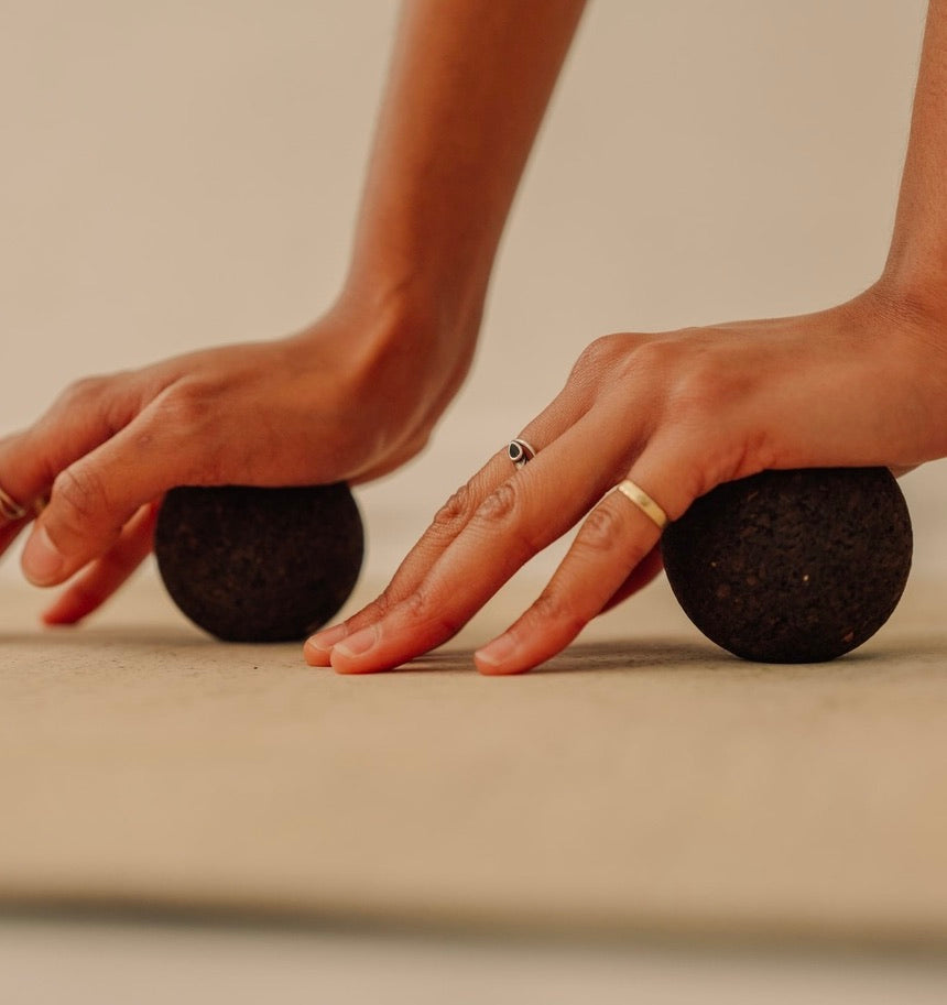 Rituil sustainable Portuguese cork massage balls for yoga, Pilates core workouts, and deep tissue muscle recovery shown on cork yoga mat with hand pressing in to balls