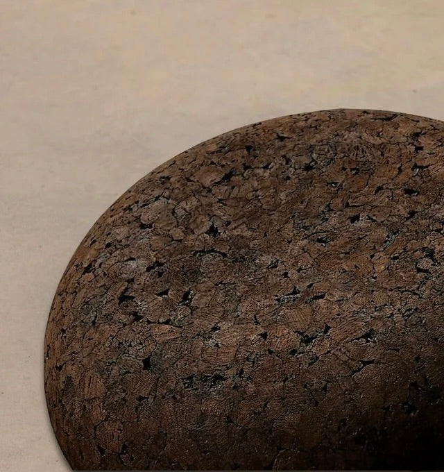 Close up of Rituil Meditation Seat made from sustainable natural cork in an earth tone resting on a concrete floor.