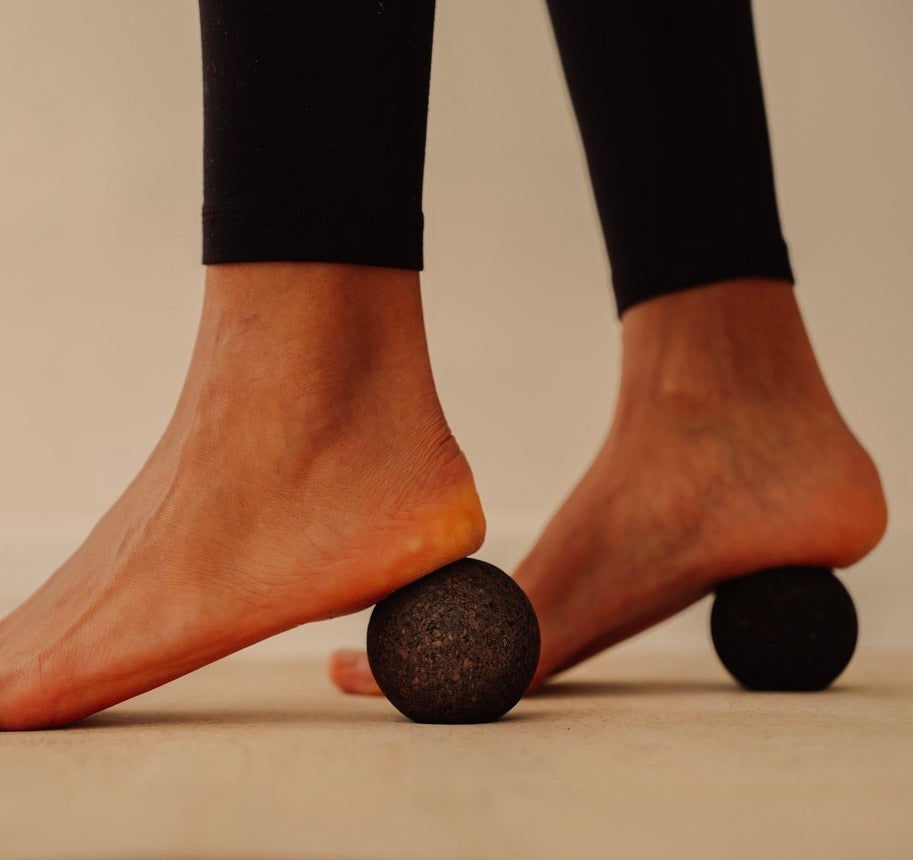 Rituil sustainable Portuguese cork massage balls pressing into woman feet on top of cork yoga mat