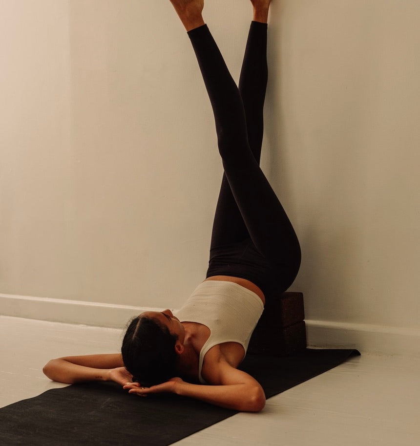 woman  with legs up wall using on brown cork mat and cork blocks