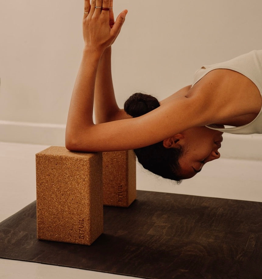 Rituil sustainable natural brown cork leather yoga mat featuring a non-slip, non-toxic, pvc free, with natural cork yoga blocks and woman practicing yoga 