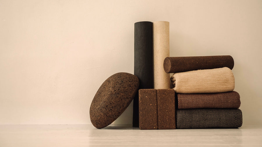 Rituil luxury cork leather yoga mats, blocks, rugs and meditation essentials on white floor.