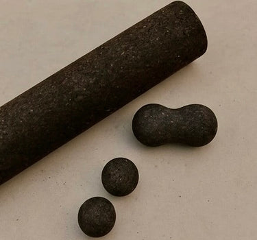 cork massage roller, peanut and spheres in brown on concrete floor