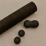 cork massage roller, peanut and spheres in brown on concrete floor