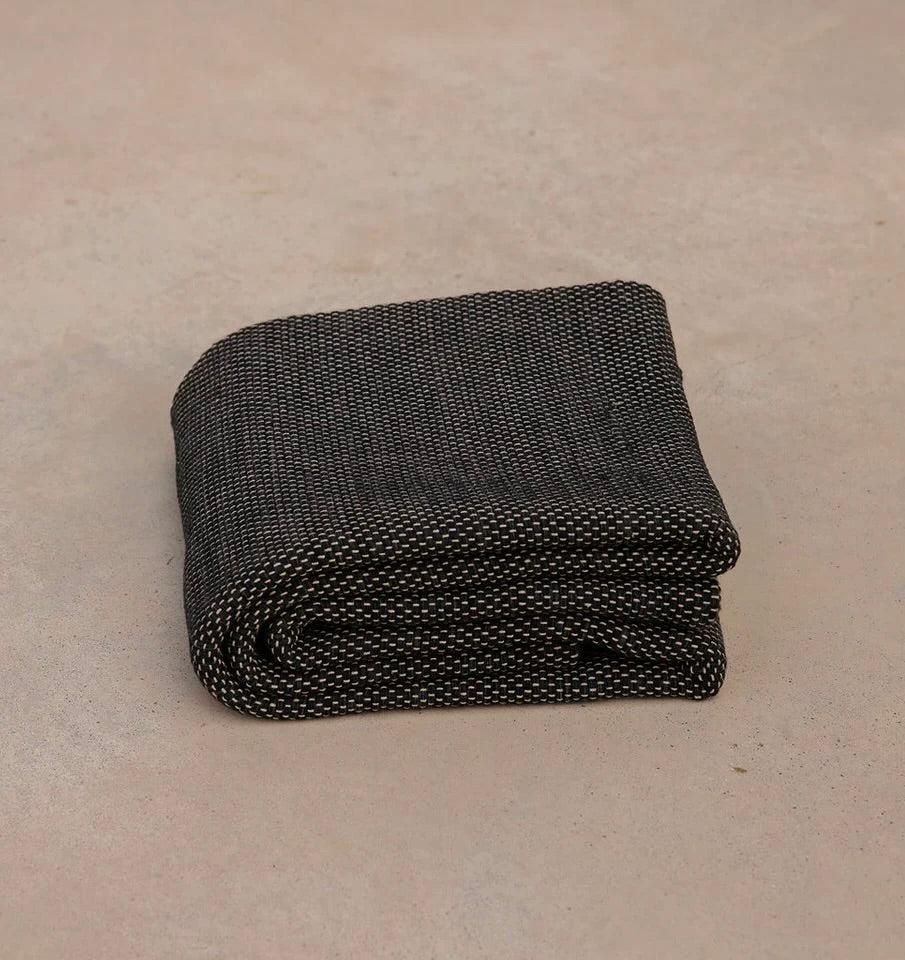 black non toxic restorative yoga rug  folded on concrete floor #color_ash