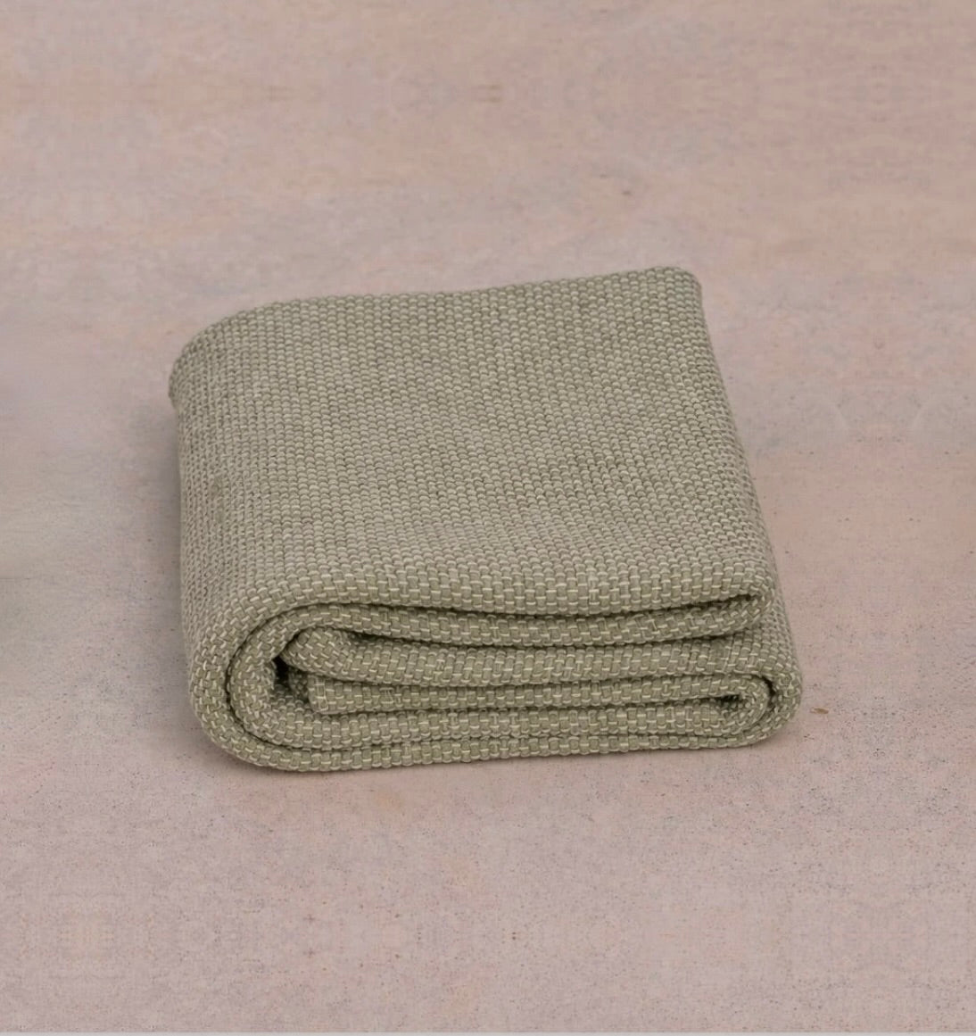 cream non toxic restorative yoga rug  folded on concrete floor #color_bone
