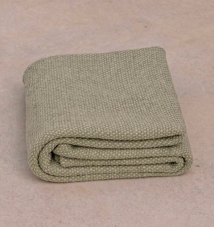 Oversized sustainable recycled cotton restorative yoga rug in tan color from Rituil folded on studio floor #color_bone