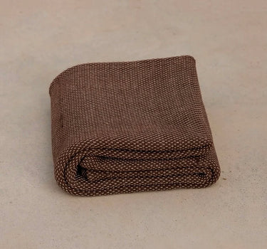 brown non toxic restorative yoga rug  folded on concrete floor #color_earth
