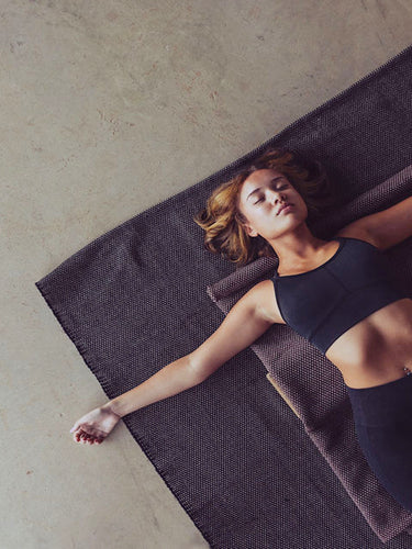 woman laying on cotton yoga rug