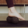 woman rolling foot on cork massage peanut