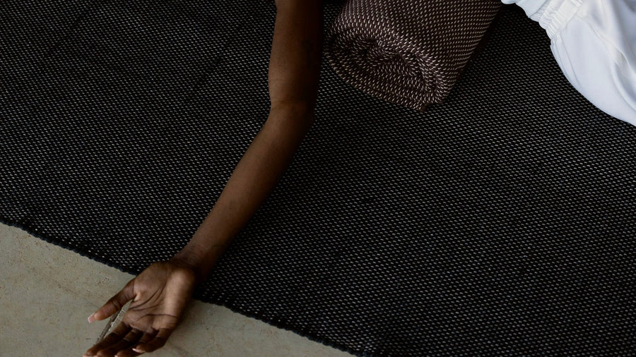 woman laying down on natural cotton yoga rug