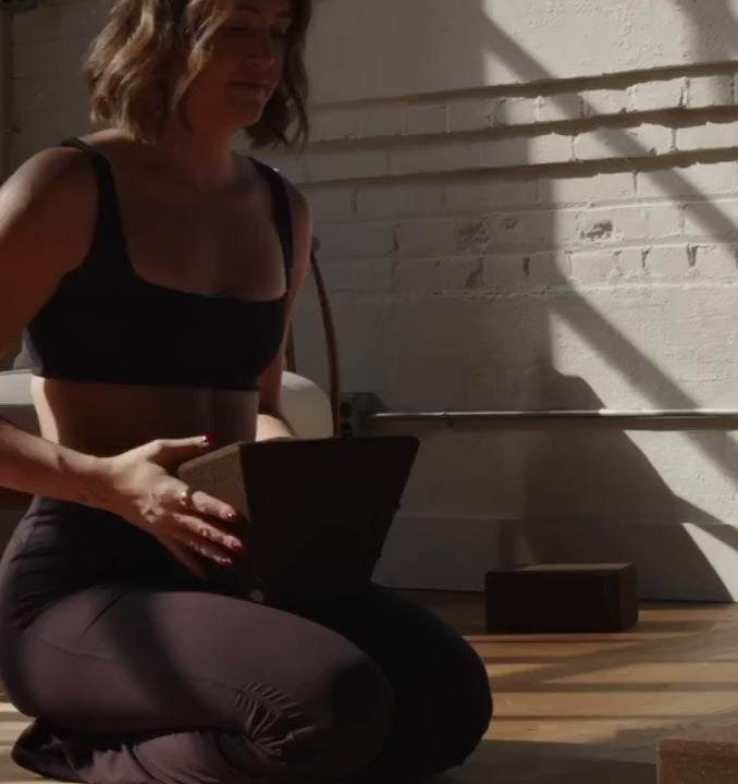 Woman practicing restorative yoga with rituil restorative cork yoga block and non-toxic cork leather yoga mat. 