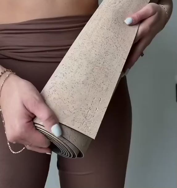 woman with rituil cork yoga mat practicting yoga in studio