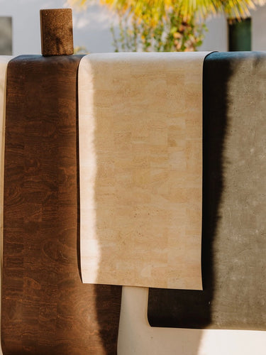 three hanging natural cork leather non slip yoga mats over a wall