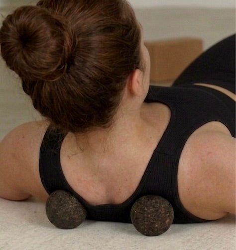 Person using a massage cork spheres on their back