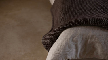 rituil cotton yoga rug brown on end of bed