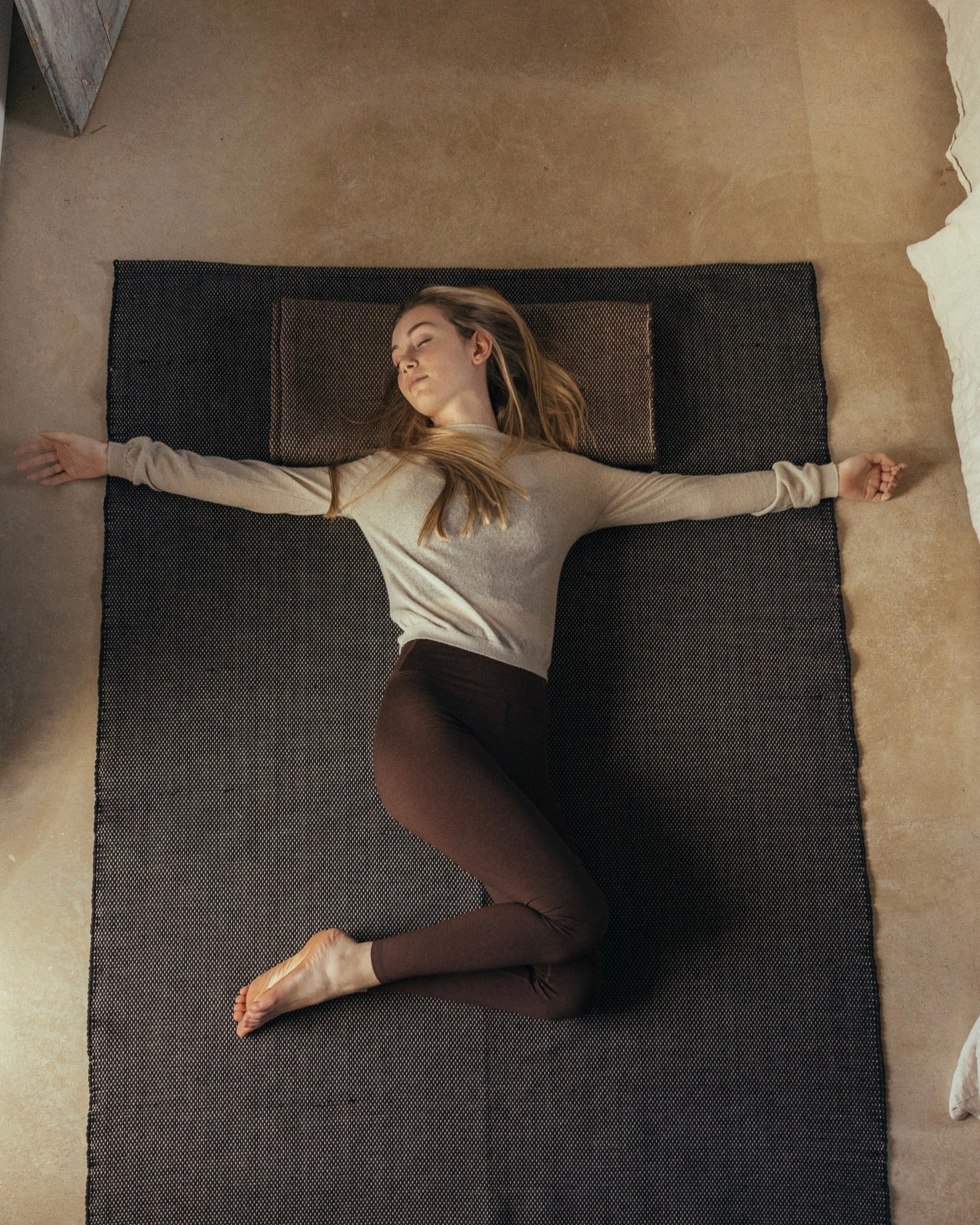 woman laying on rituil cotton yoga rug