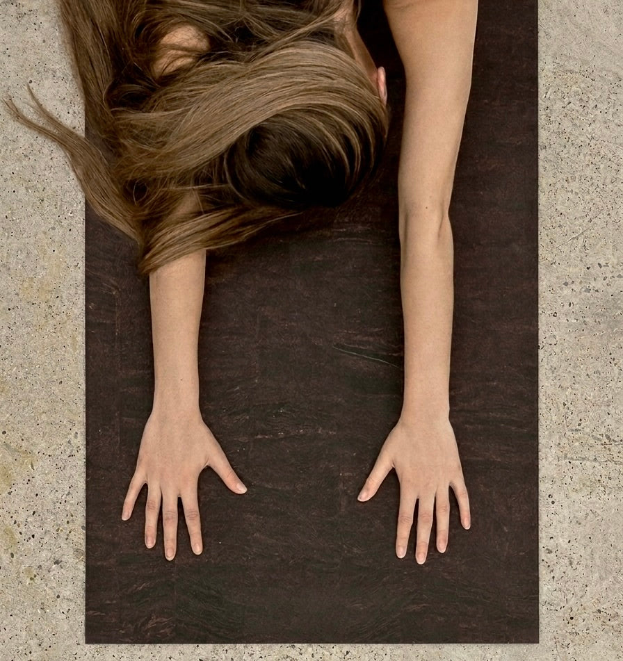 womans hands in childs pose on Rituil earth or brown colored cork yoga mat #color_earth