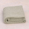 Oversized sustainable recycled cotton restorative yoga rug in tan color from Rituil folded on studio floor 
