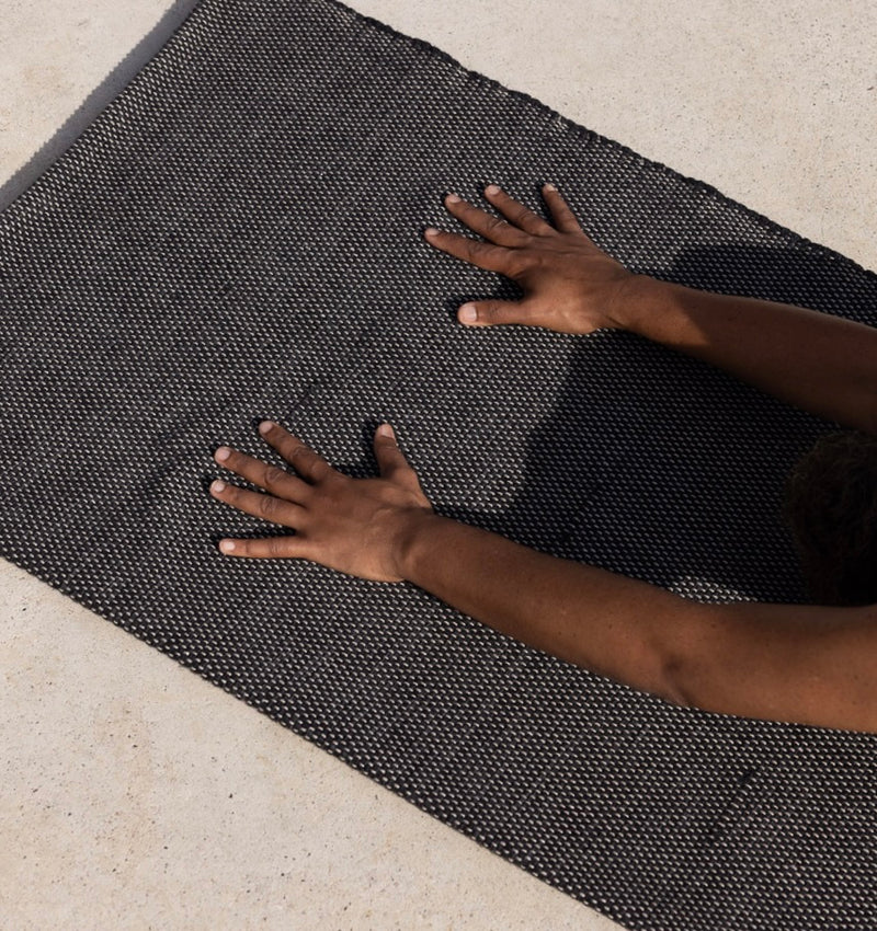 Woman practicing yoga on Rituil cotton yoga rug
